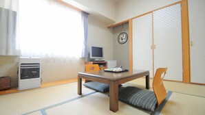 A traditional Japanese room with tatami flooring, a low table, a television, and sliding doors. - Hotel Saharin (Wakkanai)