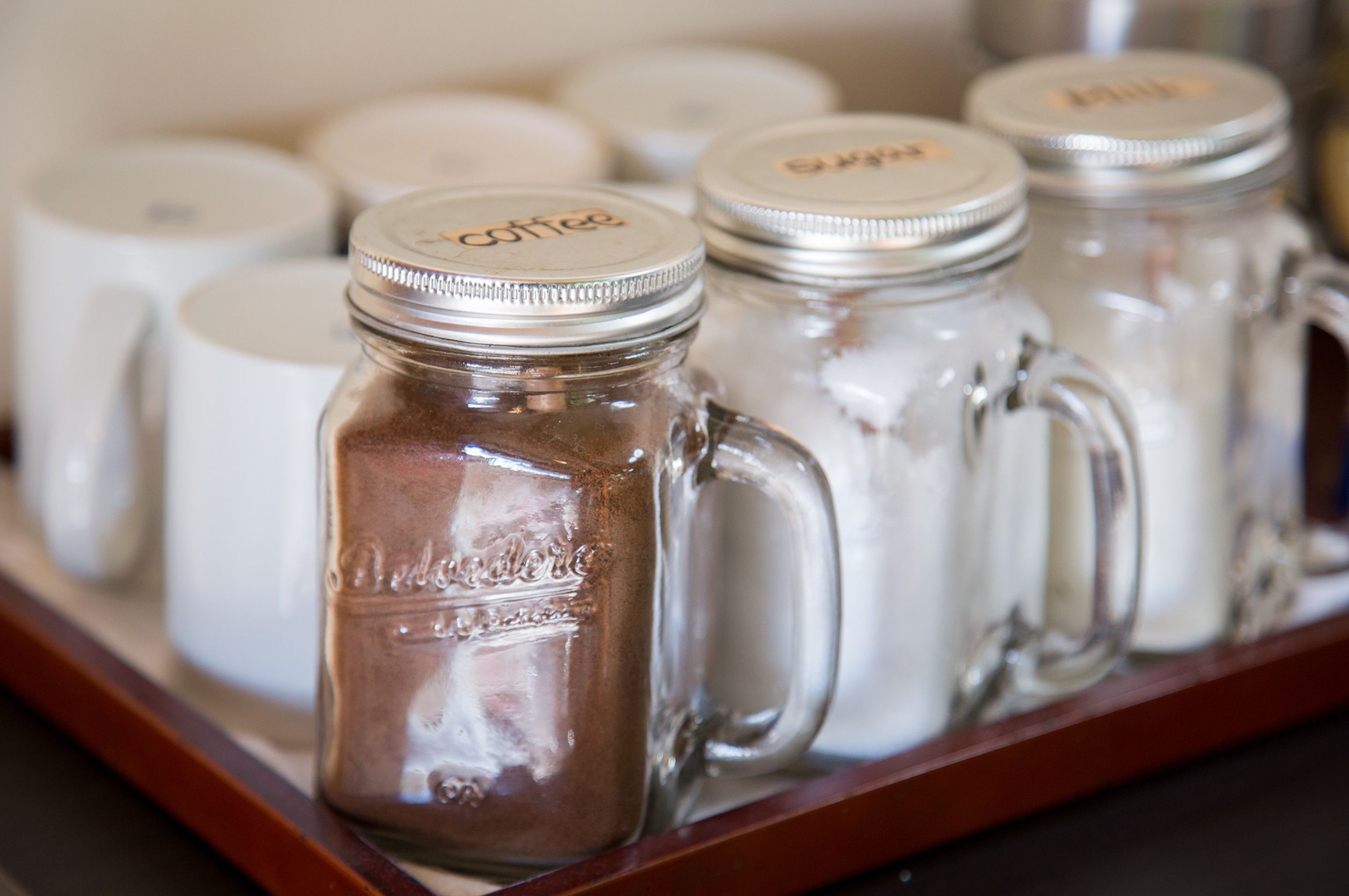 A tray with several glass jars labeled "coffee" and "tea," suggesting a beverage service.