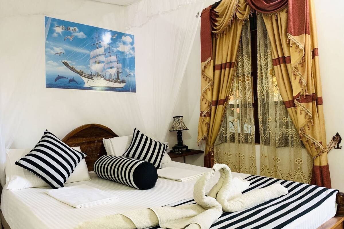 A bed with striped bedding, a headboard, and pillows.