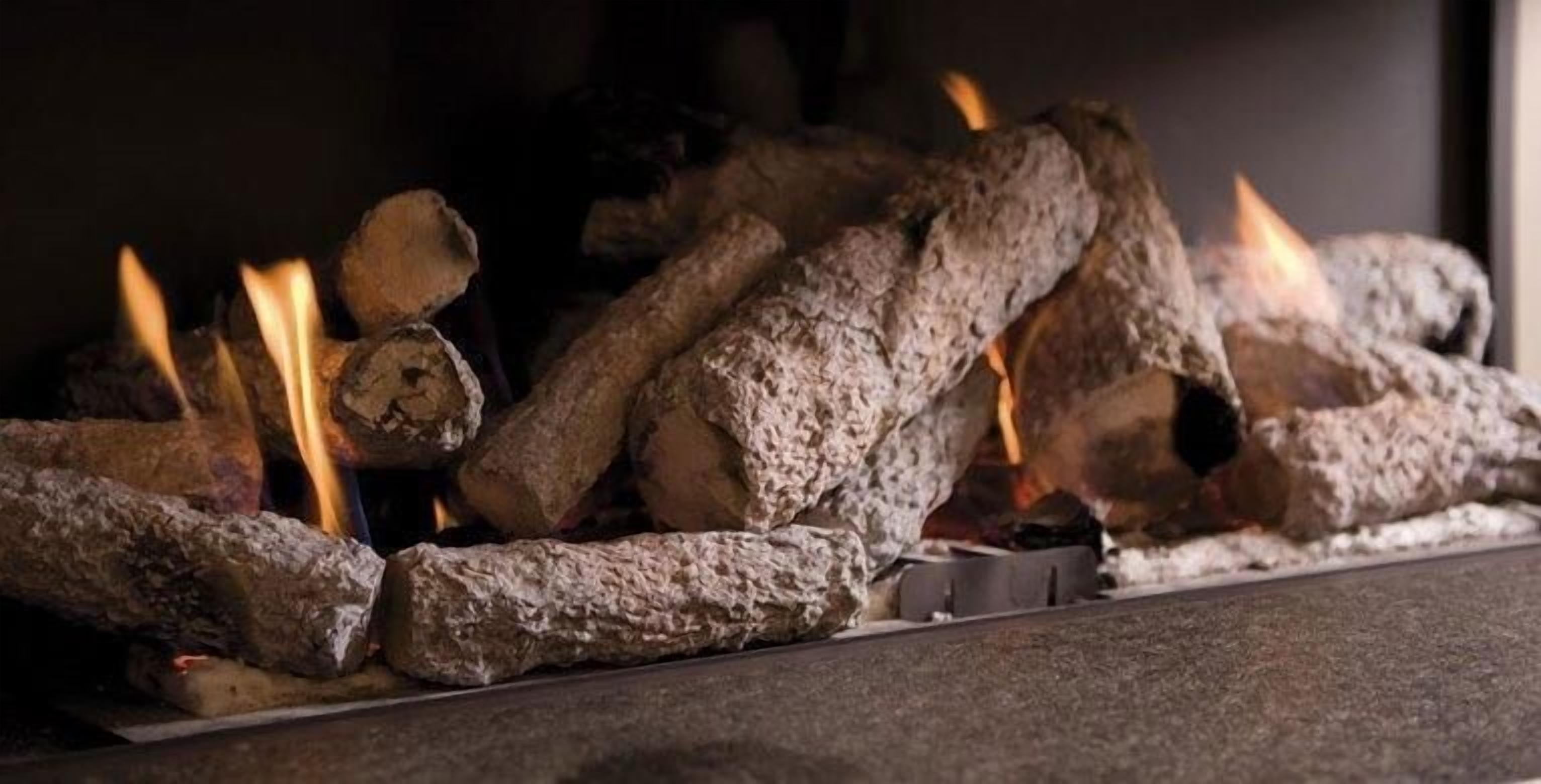 Une cheminée avec des bûches et des flammes.