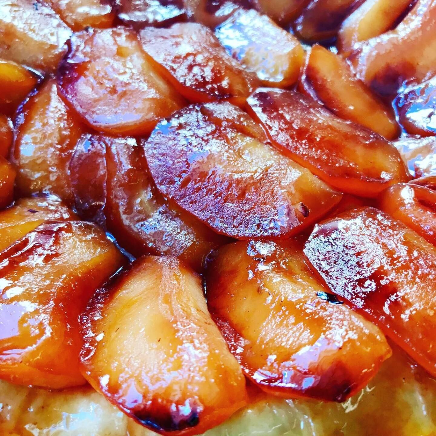 A close-up of glazed fruit, likely apples, with a shiny, caramelized surface.
