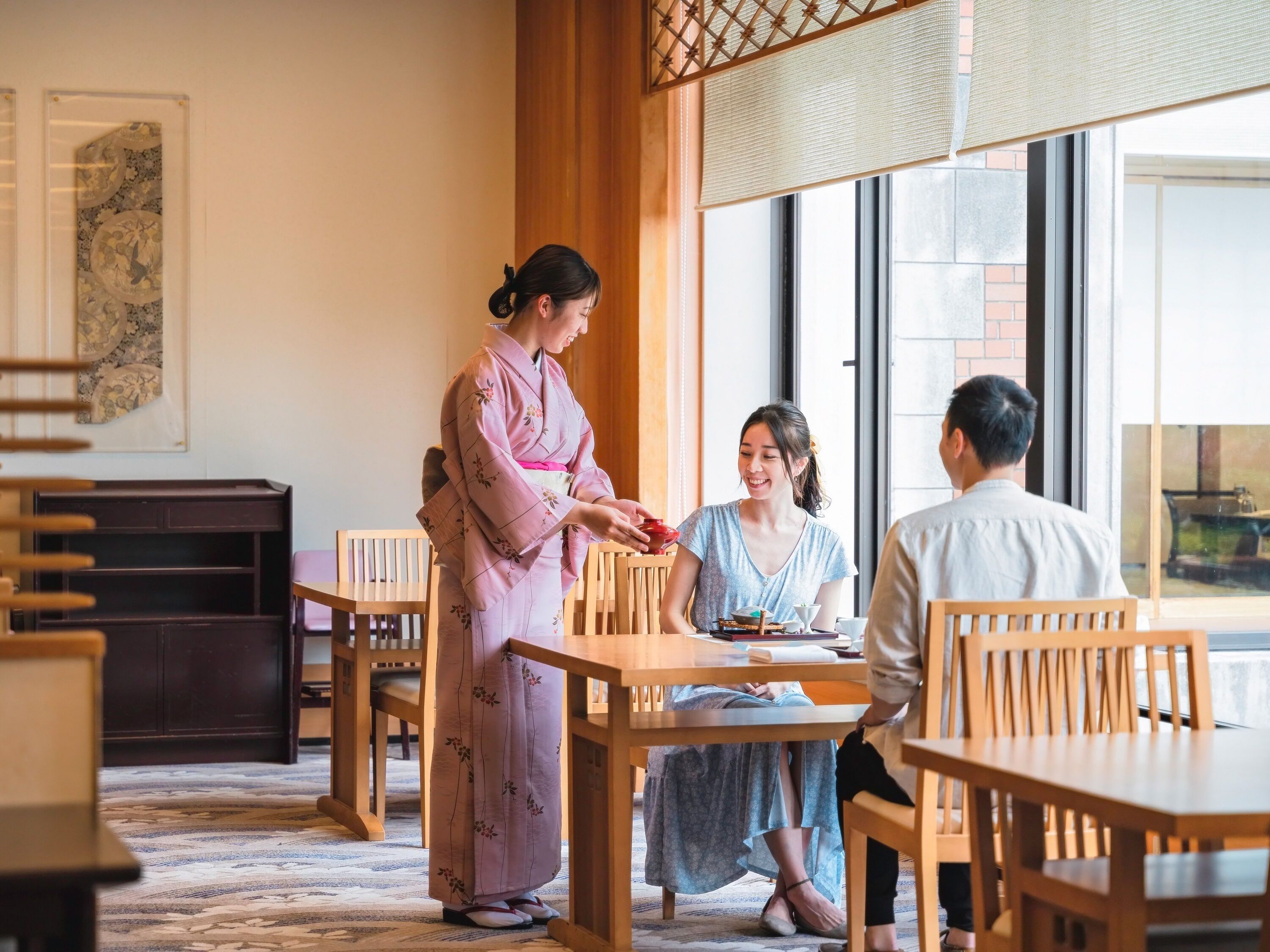 A traditional room with tatami flooring, wooden furniture, and a sliding door.