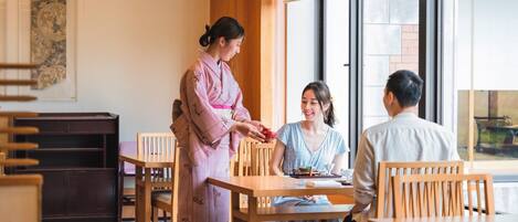 A traditional room with tatami flooring, wooden furniture, and a sliding door.