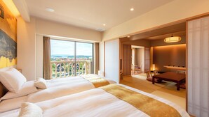 A hotel room with two beds, a balcony with a view, a dining area, and a sliding door leading to another room. - Hotel Okura JR Huis Ten Bosch (Sasebo)