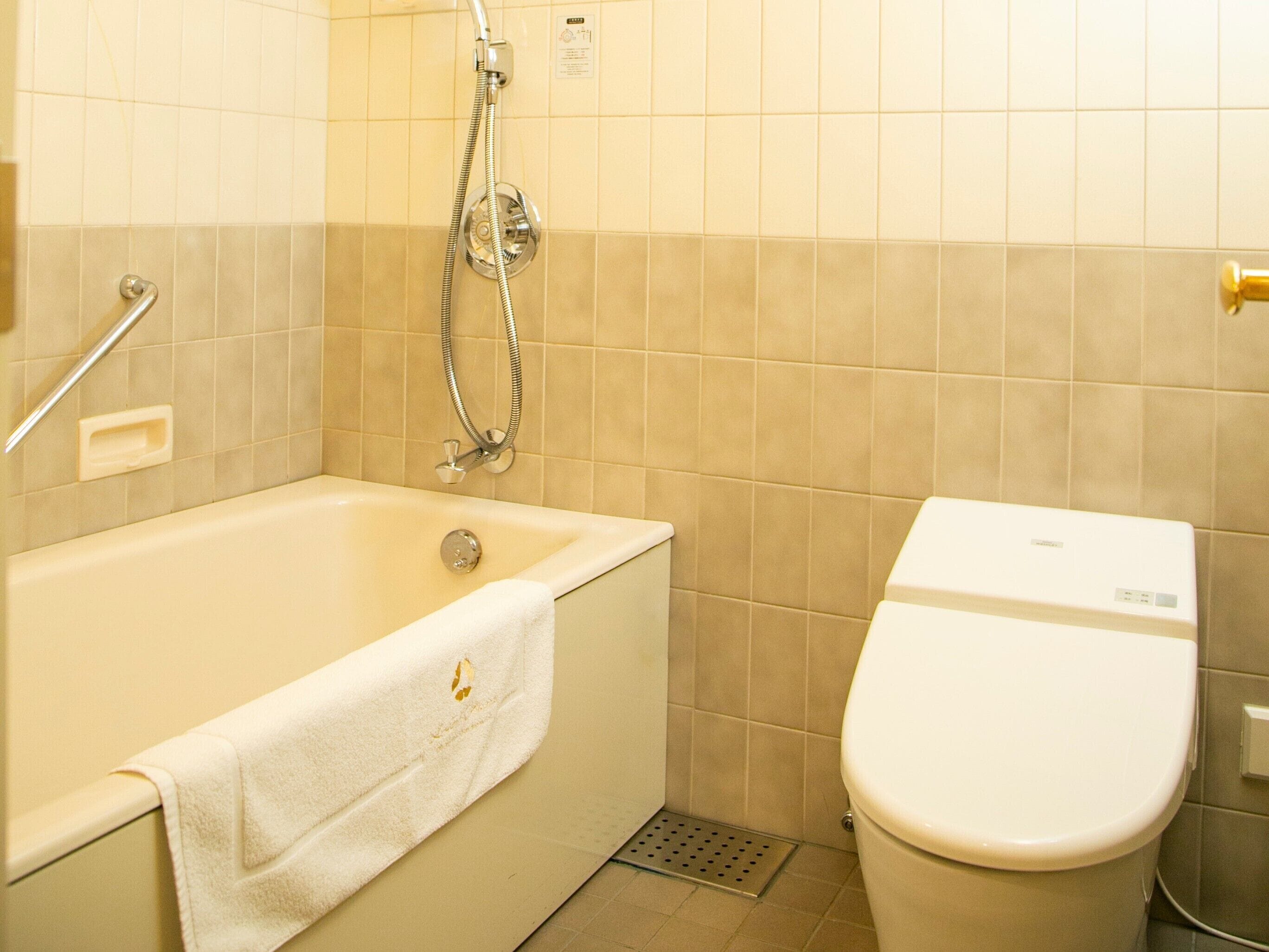 A bathroom with a bathtub, a toilet, and a shower.