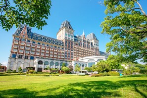A large, historic building with multiple stories, a prominent central tower, and a well-maintained garden in front. - Hotel Okura JR Huis Ten Bosch (Sasebo)