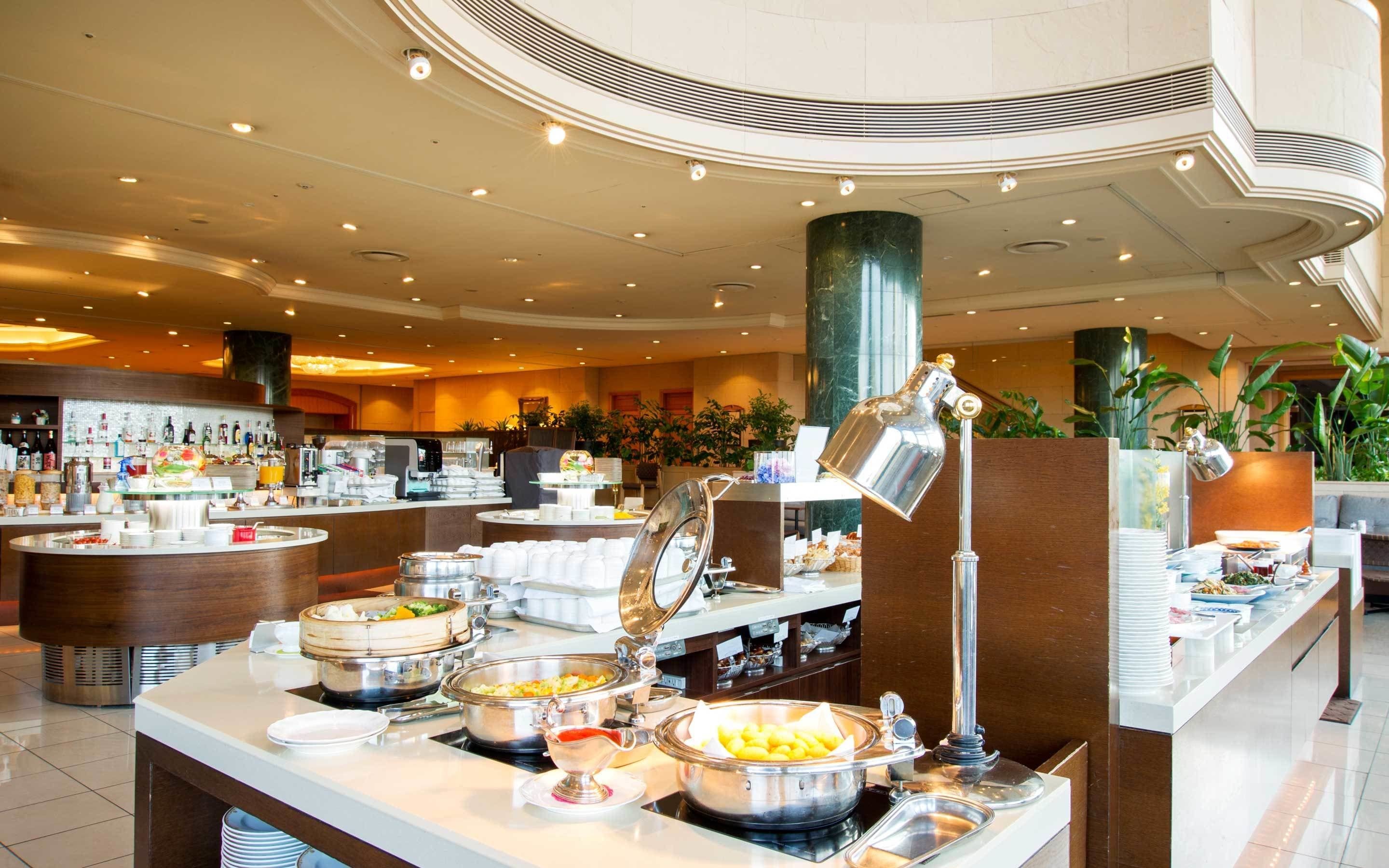 A buffet area with various food stations, including hot and cold dishes, and a coffee bar.