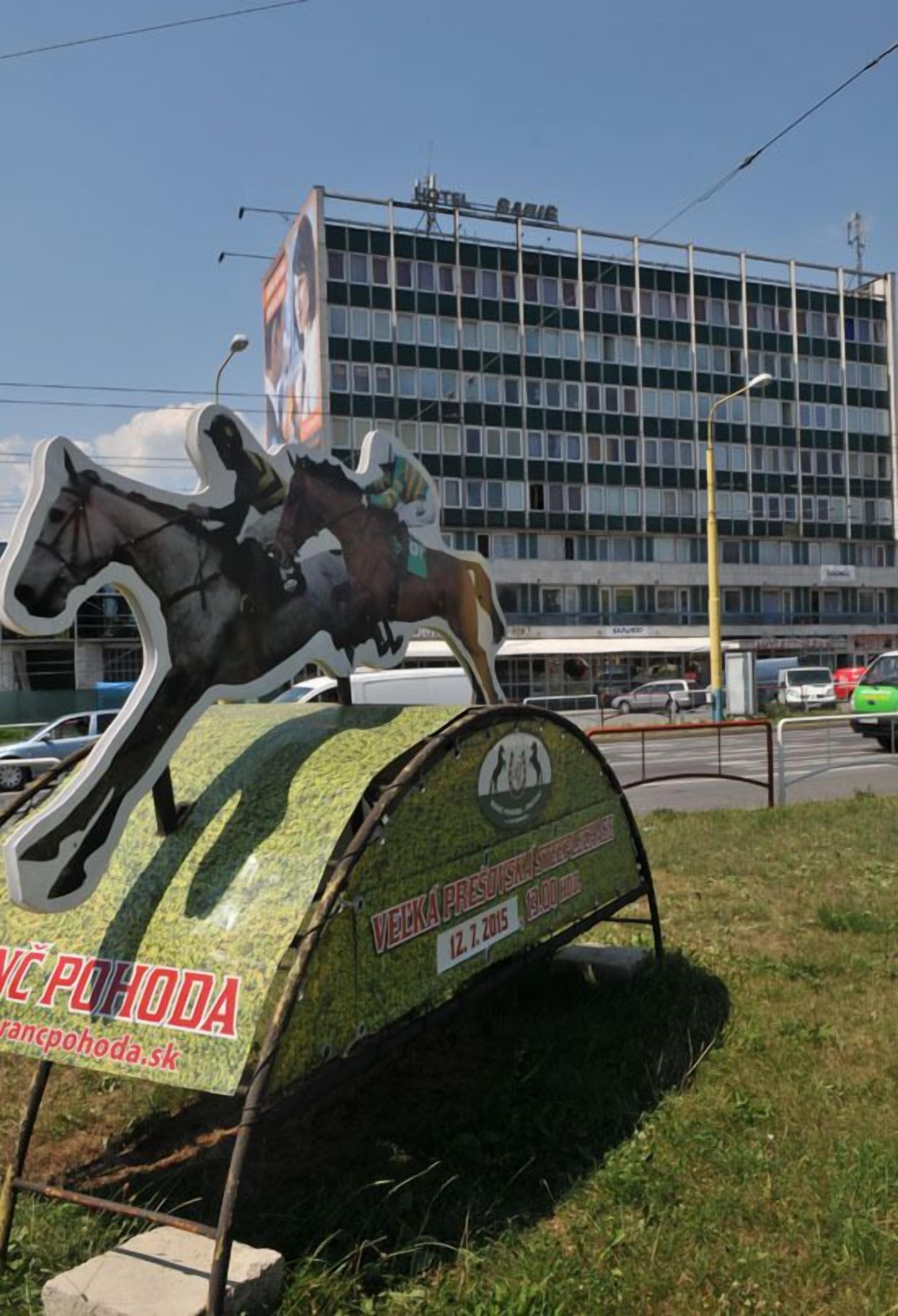 A horse sculpture with a sign in front of a building.