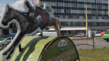 A horse sculpture with a sign in front of a building.