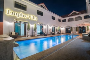 A hotel named Empire Villa with a swimming pool and outdoor seating areas.