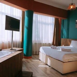 A hotel room with a bed, a TV, a sink, and a large window with curtains. - Deda Thermal Hotel (Eskisehir)