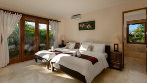 A double bed with white linens, a wooden headboard, and a red throw blanket. There are two bedside tables with lamps and a framed picture on the wall. - Balangan Beach Villa (Jimbaran)