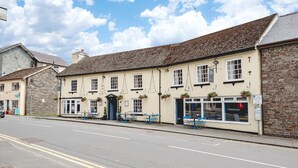 A traditional building with a stone facade, a tiled roof, and a signboard. - The Elan Hotel (Rhayader)