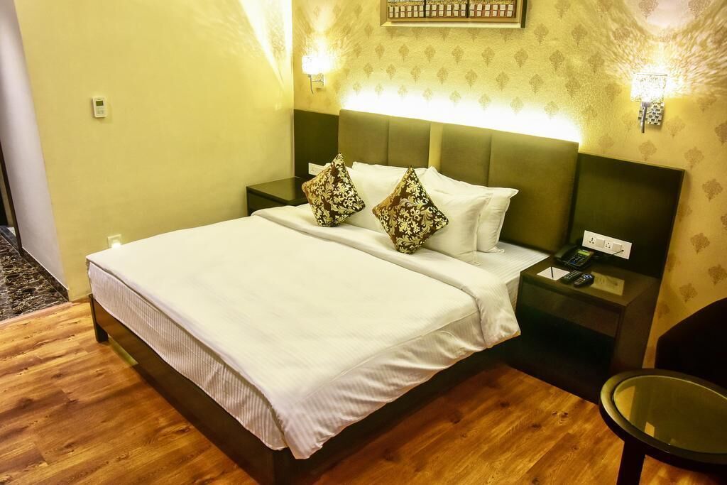 Ein Hotelzimmer mit einem Bett, Nachttischen, einem Sessel und einer Wandleuchte.