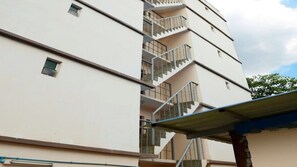 Un edificio de varios pisos con una escalera central y balcones.
