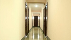 A long, narrow hallway with a polished floor and cream-colored walls. - Real Link Hotel (Yangon)