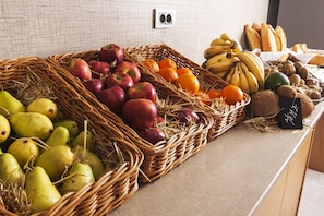 A display of fruits and vegetables in wicker baskets on a counter. -  Majura Hotel (Izmir)
