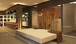 A modern lobby with a reception desk, a seating area, and a wall with vertical bamboo elements. -  Majura Hotel (Izmir)