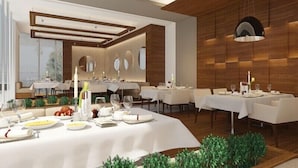 Un espace de restauration moderne, doté de plusieurs tables, de nappes blanches et d’un décor mural en bois.