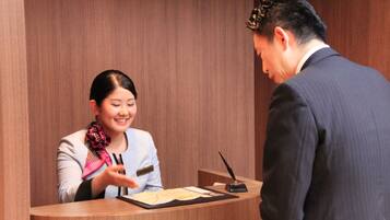 A reception desk with a wooden panel background, a nameplate, and a pen holder.