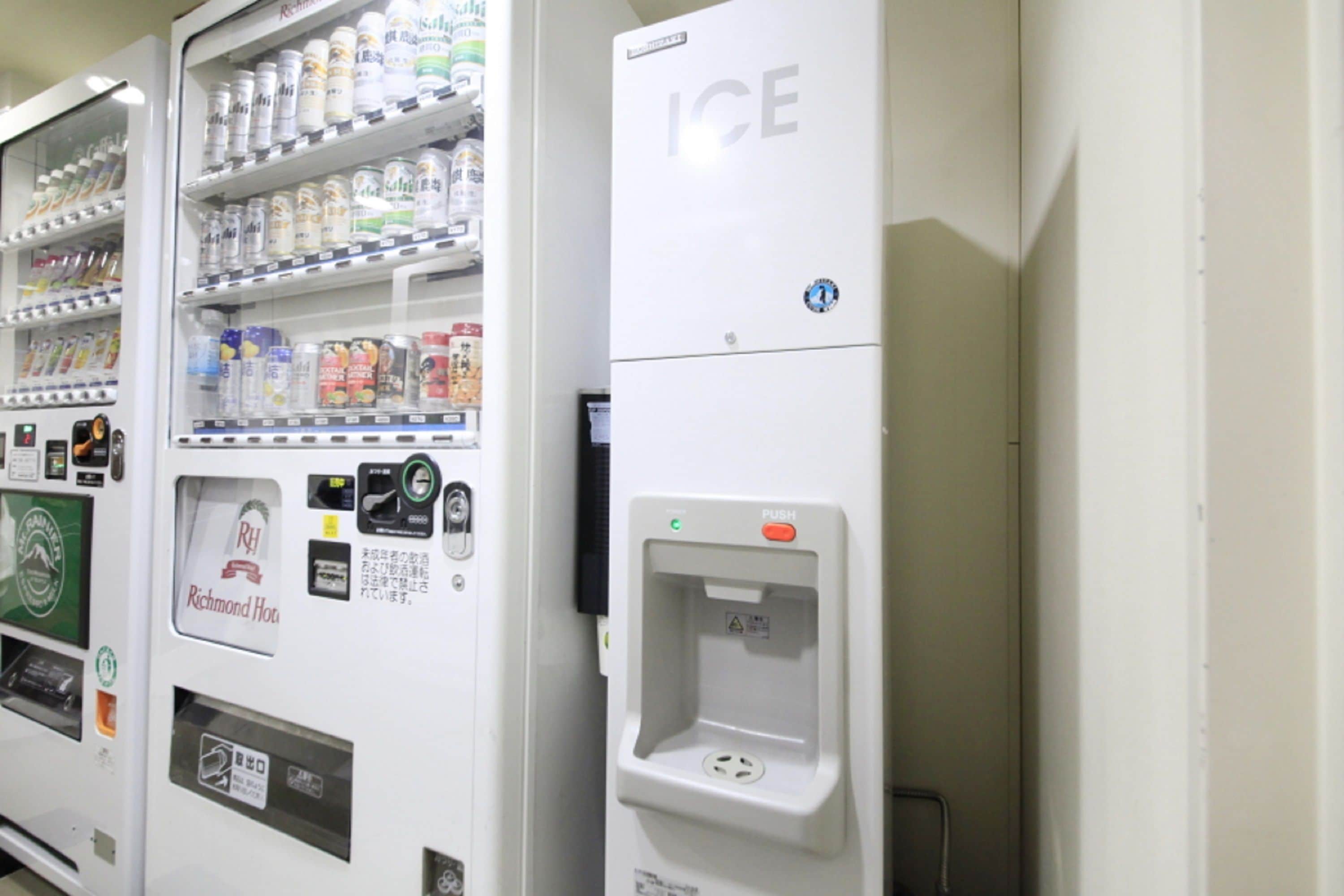 Un distributeur automatique proposant une variété de boissons et d’en-cas, dont un distributeur de glaçons bien visible.