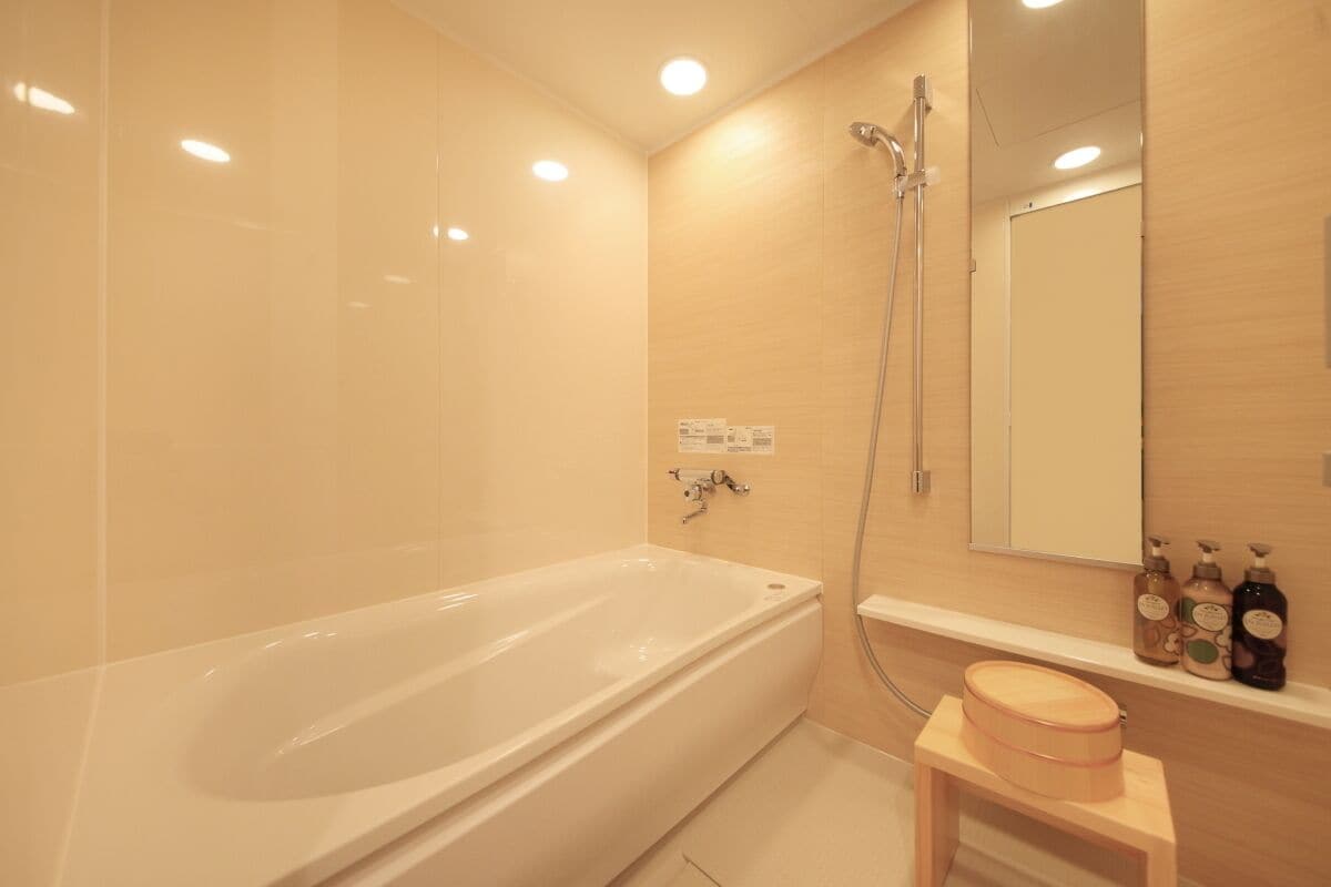 Een moderne badkamer met een badkuip, douche en wastafel.