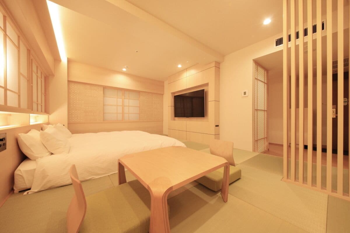 Una habitación de hotel con cama, televisión, escritorio y zona de estar.