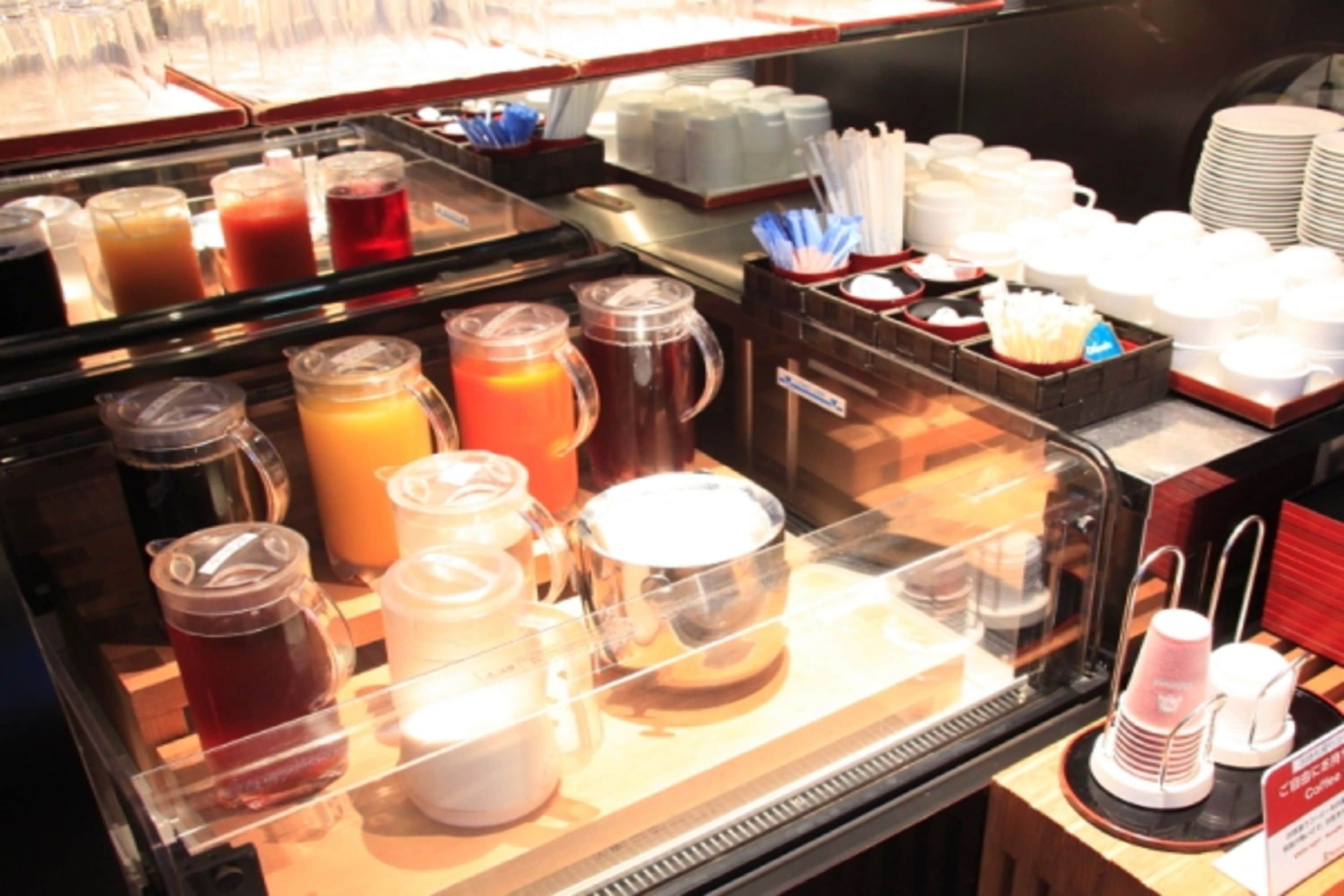 A breakfast buffet with various beverages and dishes.