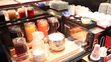 A breakfast buffet with various beverages and dishes.