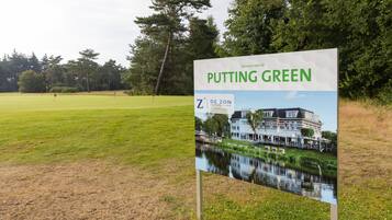 Welcome to the serene Putting Green, surrounded by lush trees and a tranquil pond.