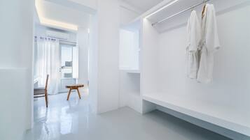 Un baño moderno y minimalista con paredes blancas, un espejo grande y un perchero para toallas.