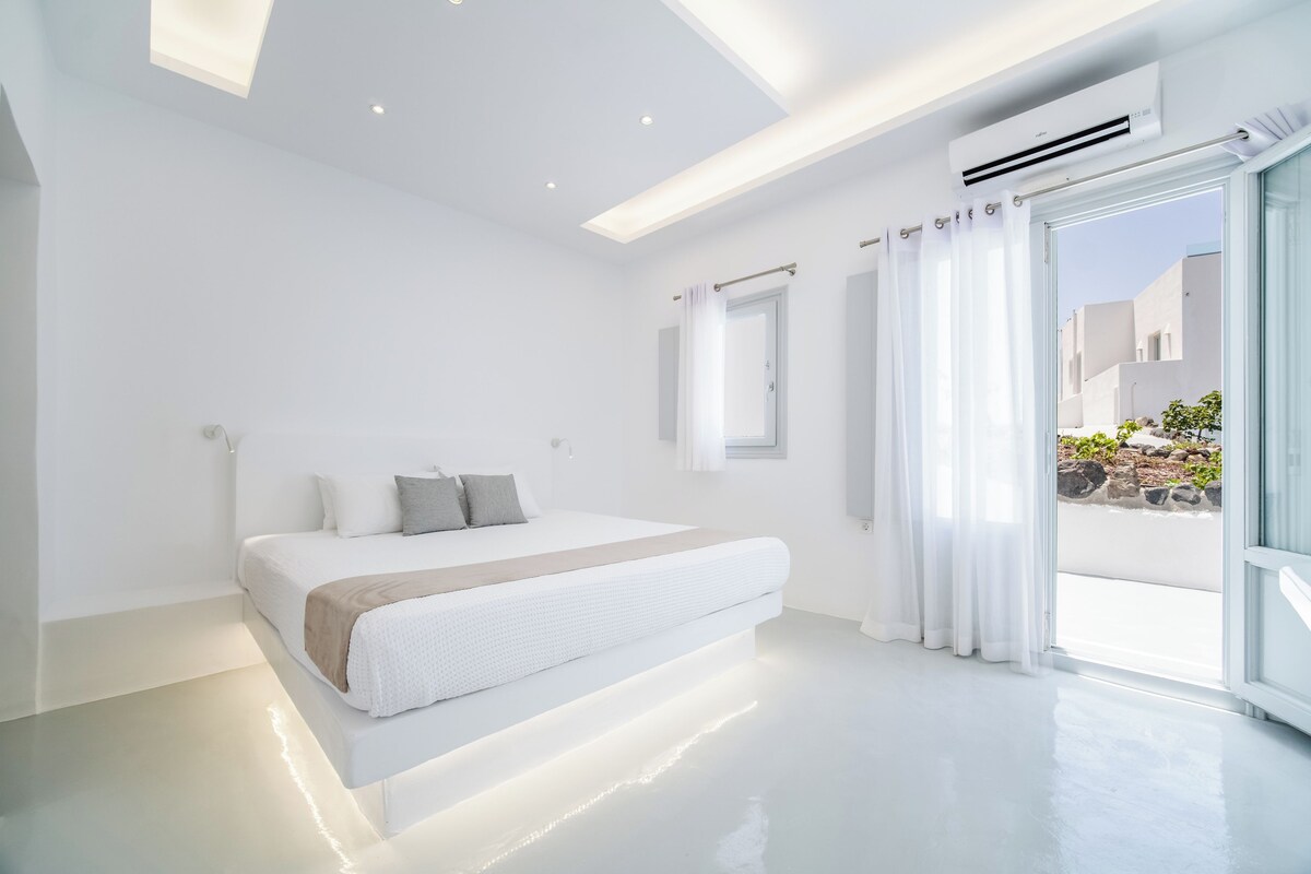A modern bedroom with a large bed, a ceiling light, and an air conditioning unit.