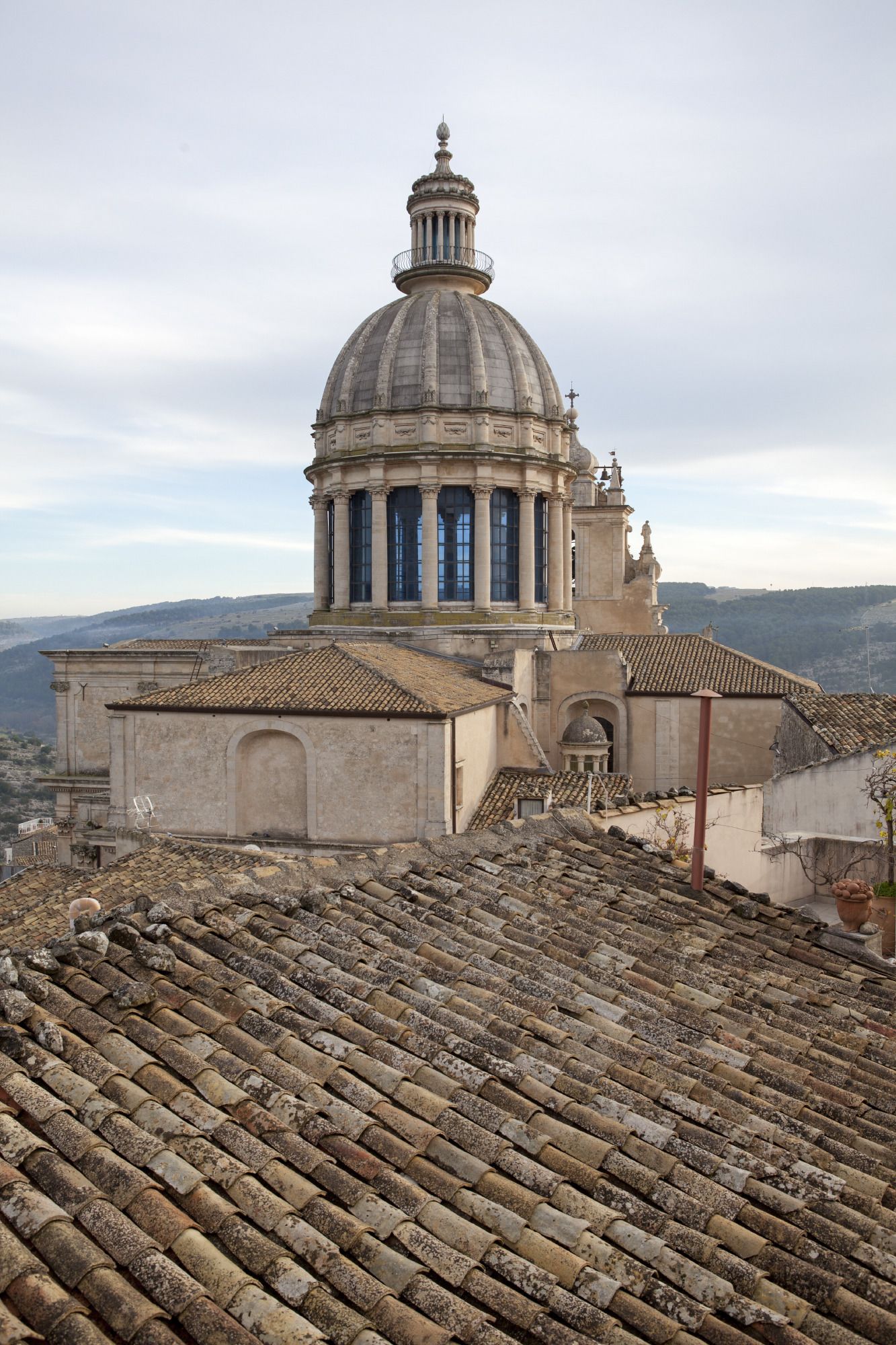 A historic building with a large dome and classical architecture, featuring a tiled roof and a bell tower.