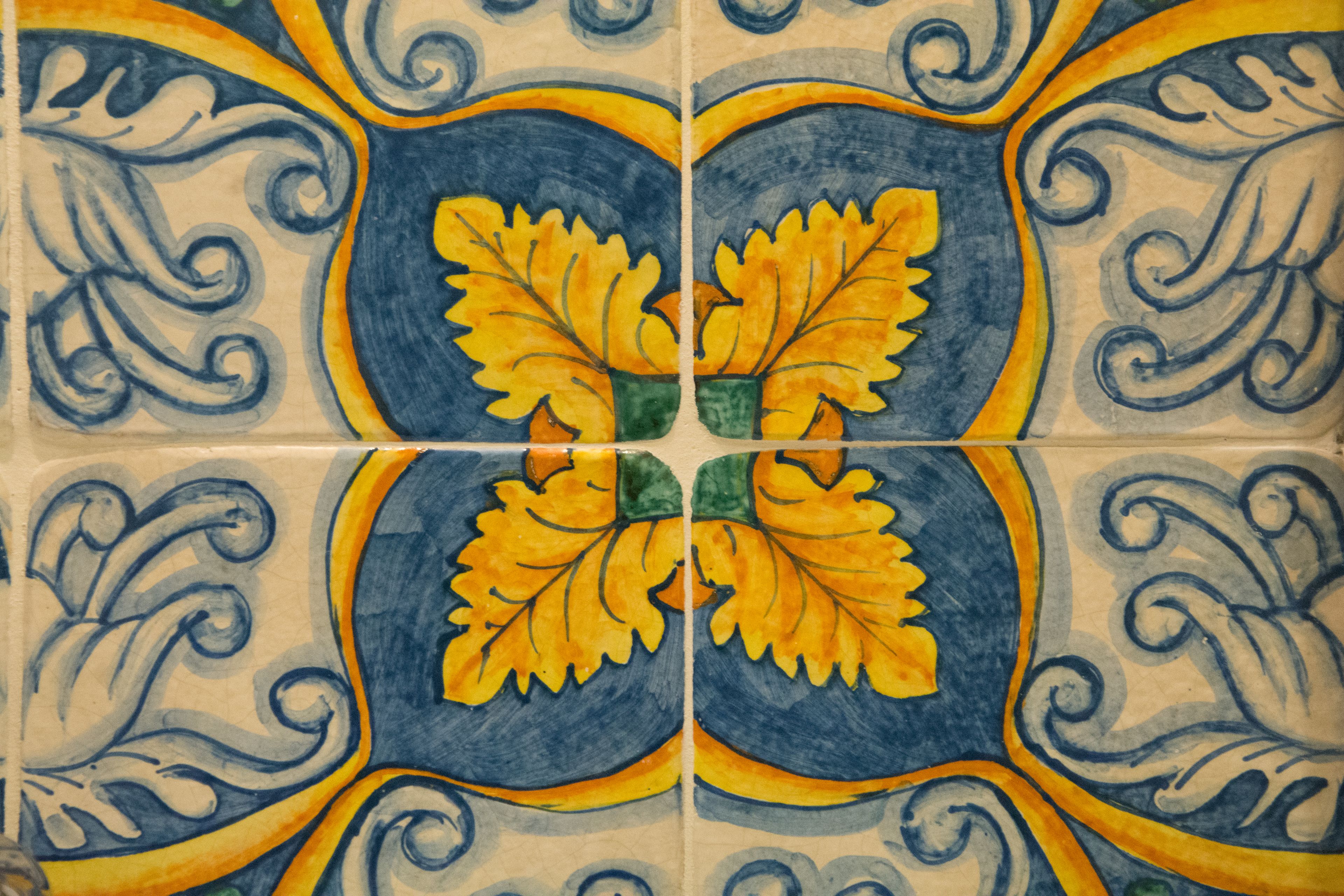 A tiled wall with a symmetrical floral pattern.