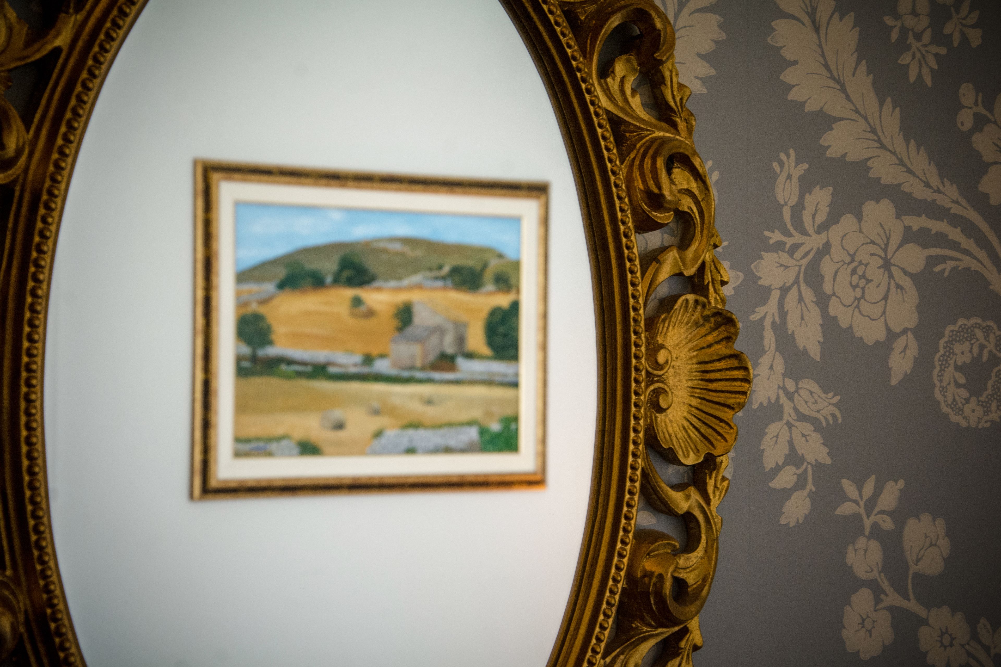 Un dipinto paesaggistico incorniciato appeso al muro.