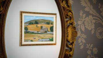 Un dipinto paesaggistico incorniciato appeso al muro.