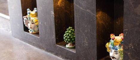 A row of dark-colored cabinets with small windows, each containing a different decorative item.