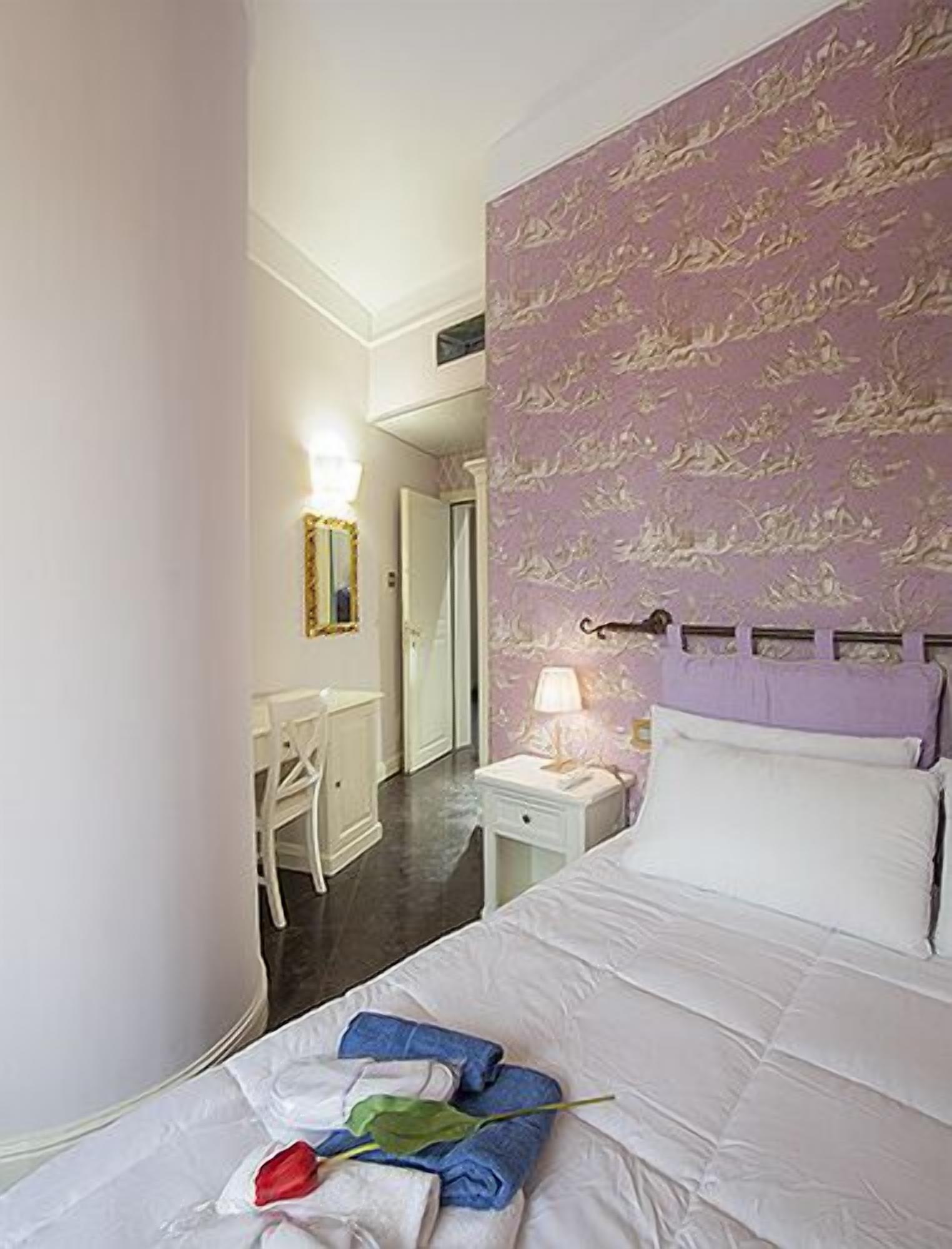 A hotel room with a bed, a desk, and a chair.