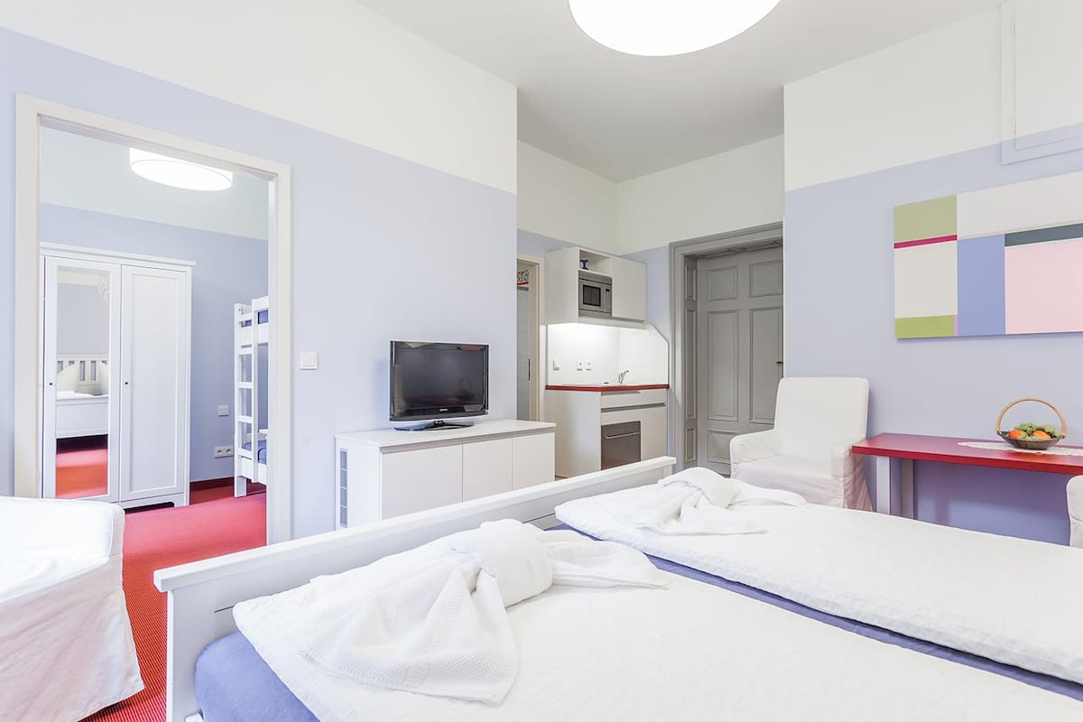 A hotel room with a bed, a TV, a desk, and a chair.