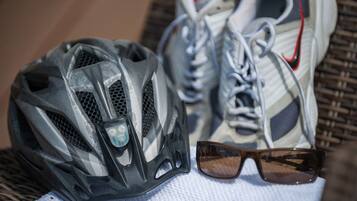 A bicycle helmet, a pair of sneakers, and sunglasses on a white towel.