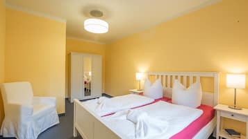 Een hotelkamer met een bed, een stoel, een kledingkast en een bureau.