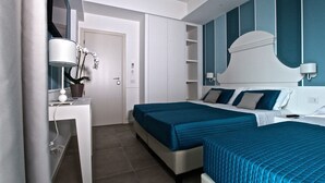 Une chambre d’hôtel moderne équipée d’un lit, de tables de chevet, d’un bureau et d’un miroir.