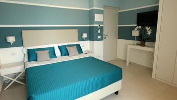 A bedroom with a bed, bedside tables, a desk, and a wardrobe.