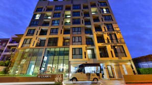 Un hôtel à plusieurs étages au design moderne, doté de balcons et de grandes fenêtres.