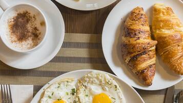 Ein Frühstücksteller mit Eiern, Schinken, Pilzen, Bohnen und Tomaten.