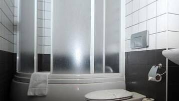 Une salle de bain moderne avec une douche à parois incurvées, des toilettes et un porte-serviettes.