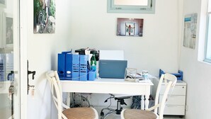 A small office space with a white desk, two white chairs, a laptop, and various office supplies. - Alura Boutique Hotel (Cesme)