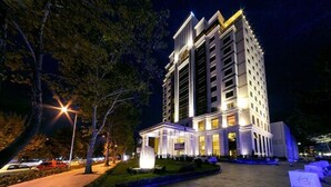 A multi-story hotel with a central courtyard, illuminated by street lamps and decorative lighting.
