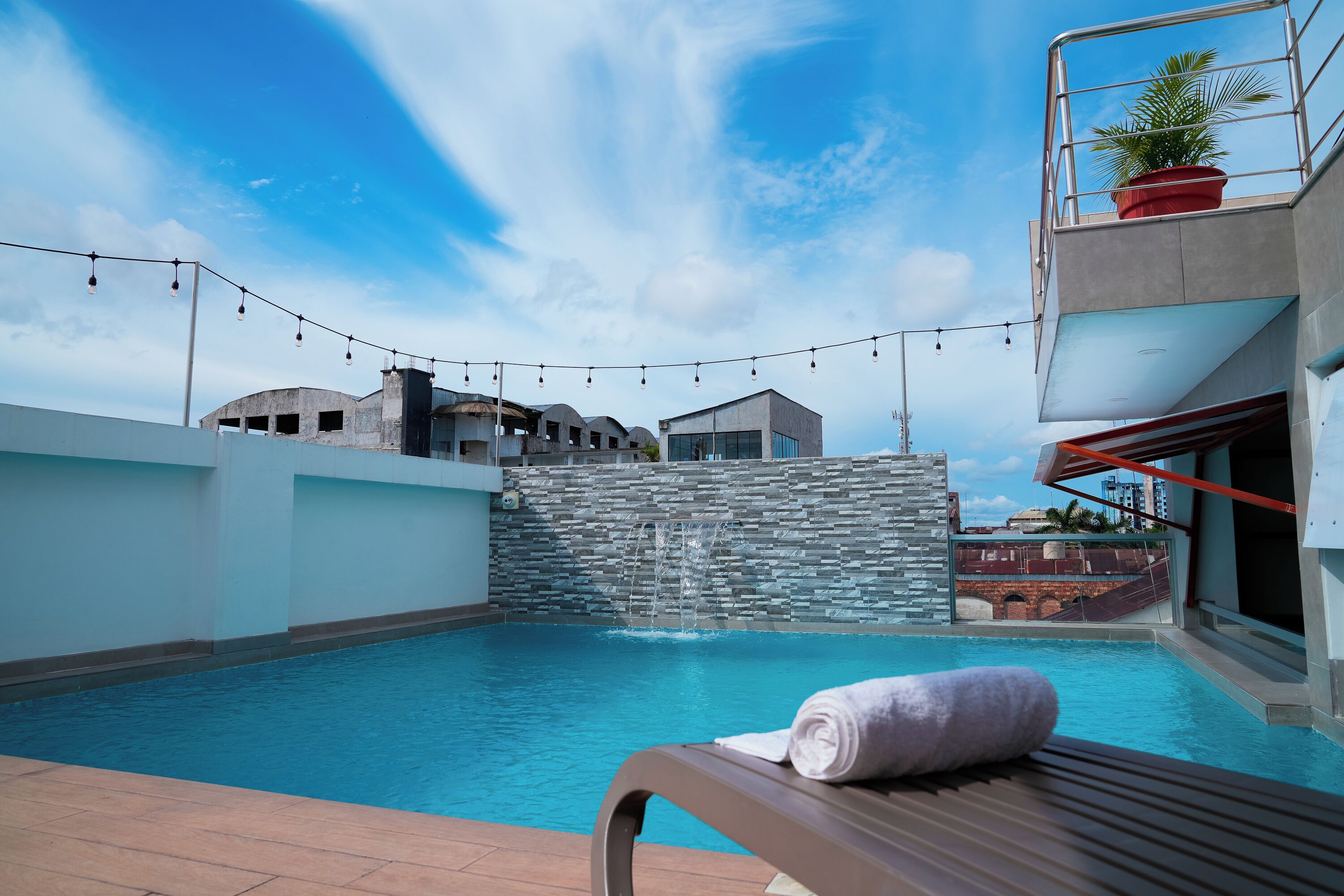 Una piscina al aire libre, sombrillas, sillones reclinables de piscina