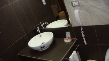 Ein Badezimmer mit zwei Waschbecken, einem Spiegel, einem Handtuchhalter und einer Toilette.